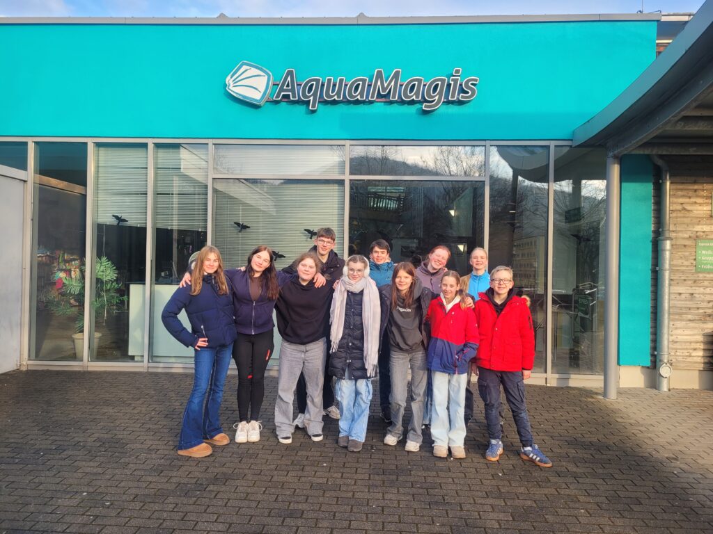 Eine Gruppe von Menschen posiert für ein Foto vor einem Gebäude.